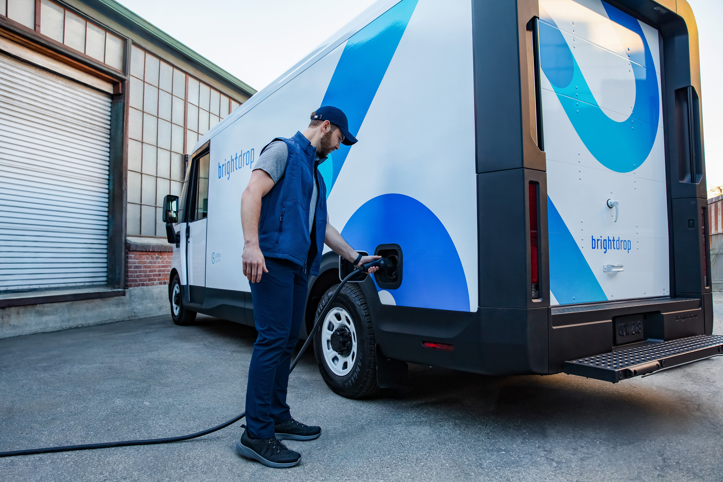 Sustainable Impact, a man charging his BrightDrop width=