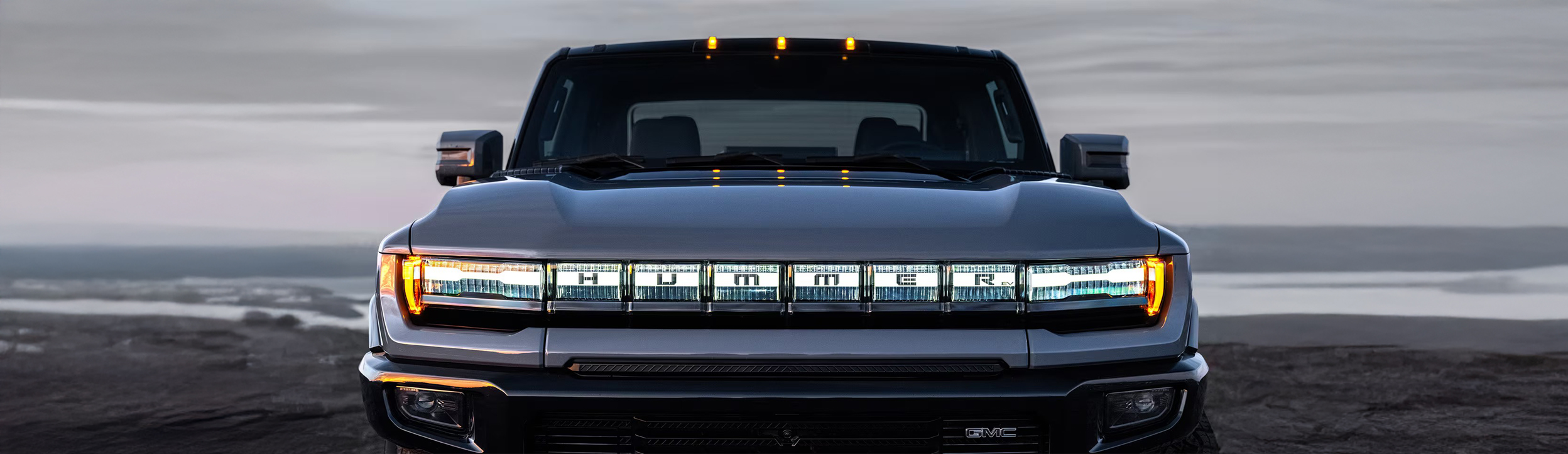 Front view of the 2025 Hummer EV Pickup Truck with its headlamps lit up.