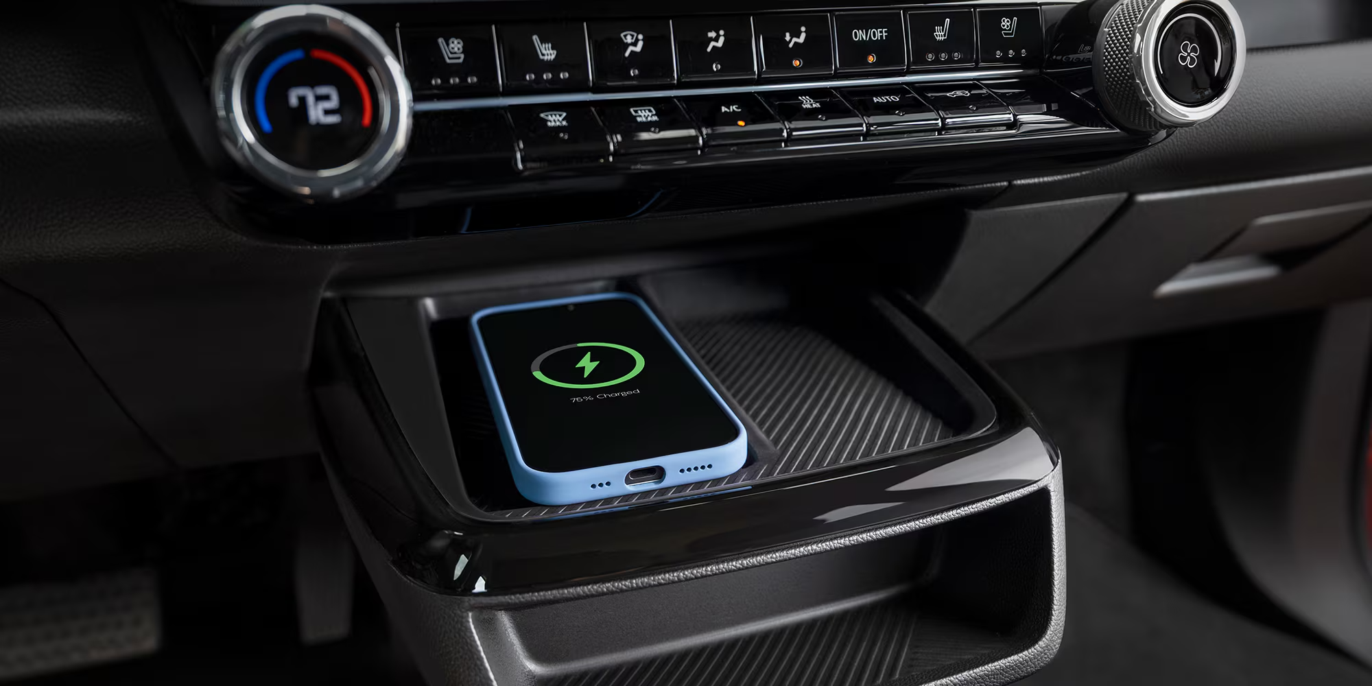 The Interior Center Console of a 2027 Chevrolet Bolt, Showing a Light Purple Smartphone Resting on the Wireless Charging Pad.